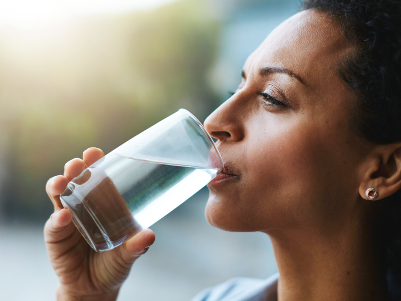 Frau trink ein Glas Wasser.